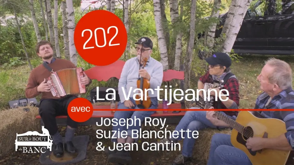 4 personnes jouent de la musique trad sur un banc, dehors sur une journée automnale. Accordéon, banjo et guitar.