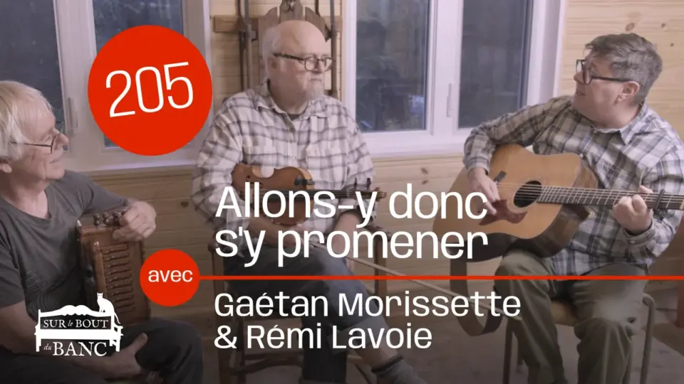 Trois hommes chantant, un joue la guitare