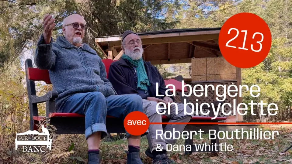 Deux hommes chantent sur un banc rouge à l'automne, entourés de feuilles et arbres