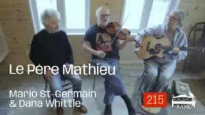 Deux hommes et une femme jouent violon, guitare et chantent ensemble dans une petite entrée de maison en été