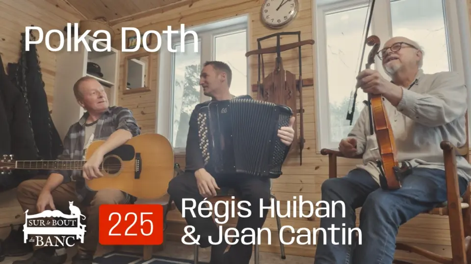 Trois hommes jouent de la musique trad dans une entrée de maison à la guitare, à l'accordéon et au violon