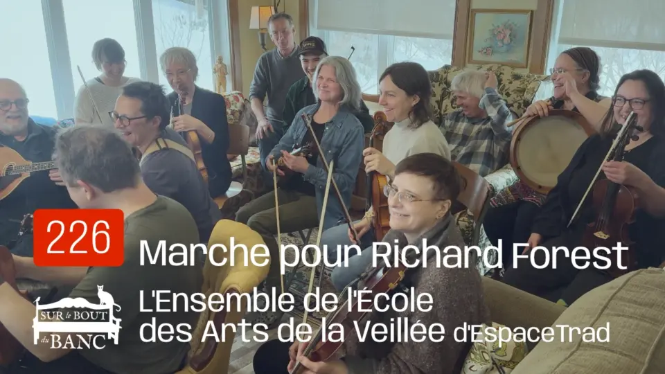 Un groupe de musicien(ne)s joue de la musique trad aux violons, banjo, mandola, bodhran et flute - dans un salon.