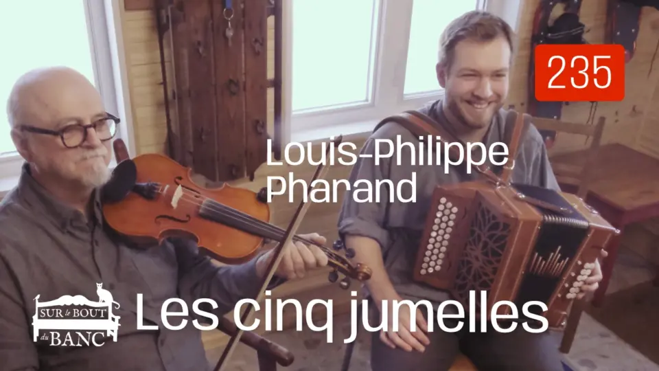 Deux hommes jouent violon et accordéon dans une entrée de maison