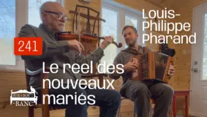 Deux hommes jouent violon et accordéon dans une entrée de maison.